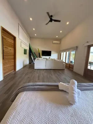 a living room with a bed and a ceiling fan at Tropical House Relaxation with Private Pool in Santa Cruz
