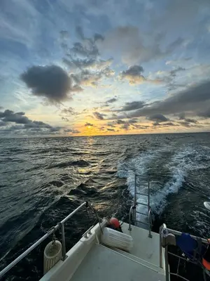 a boat in the ocean with a sunset at Tropical House Relaxation with Private Pool in Santa Cruz