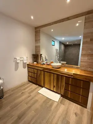 a bathroom with a sink and a large mirror at Tropical House Relaxation with Private Pool in Santa Cruz