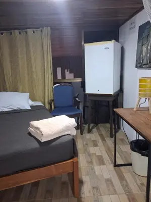 a room with a bed and a tv and a desk at The cheap bed, by Natural Pacific Suites in Tapantí