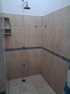 a bathroom with a shower with tiled floors and a ceiling at The cheap bed, by Natural Pacific Suites in Tapantí