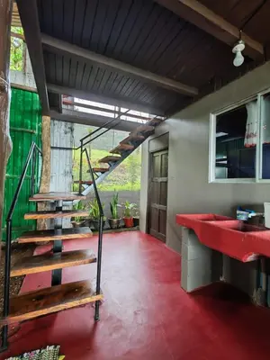 a room with a staircase and a red floor at Cabaña vista al miravalles in Bijagua