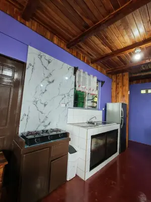 a kitchen with a counter and a marble wall at Cabaña vista al miravalles in Bijagua
