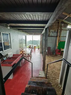 a room with stairs and tables and chairs at Cabaña vista al miravalles in Bijagua