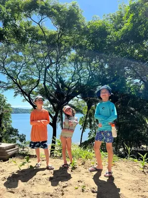 three children standing on a beach near a tree at Casa Carao Peninsula de Nicoya - front beach