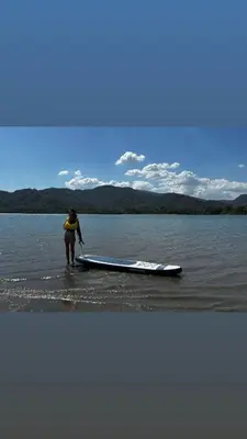 a person standing in the water next to a kayak at Casa Carao Peninsula de Nicoya - front beach
