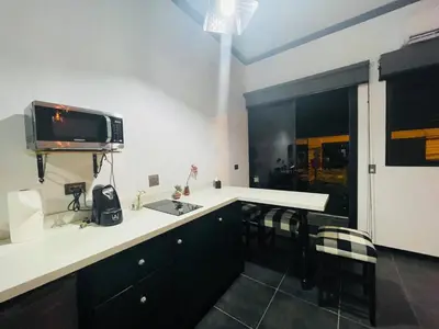 a kitchen with a sink and a tv on the wall at Cozy and Central Apartment in Alajuela, Perfect for Families in Alajuela City