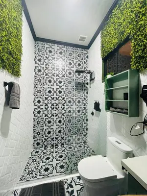 a bathroom with a black and white tile wall at Cozy and Central Apartment in Alajuela, Perfect for Families in Alajuela City