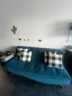 a blue couch with pillows in a room at Cozy and Central Apartment in Alajuela, Perfect for Families in Alajuela City