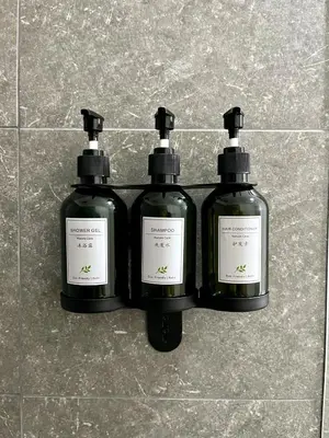 three bottles of soap sitting on a tiled floor at Apartamento en San José in San José