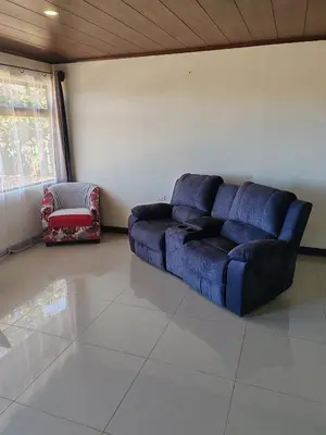 a living room with a blue couch and a chair at Apartamentos Casa Don Luis in Monteverde Costa Rica