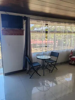 a table and chairs in a room with a window at Apartamentos Casa Don Luis in Monteverde Costa Rica