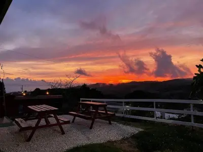 a picnic table and bench on a balcony at sunset at Apartamentos Casa Don Luis in Monteverde Costa Rica