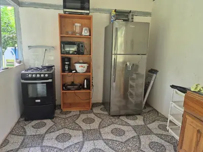 a kitchen with a refrigerator and a stove and a shelf at Cabaña Las Vegas de Acosta in San Ignacio
