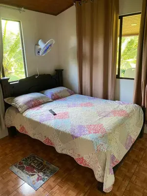 a bedroom with a bed with a comforter and a window at Cabaña Las Vegas de Acosta in San Ignacio