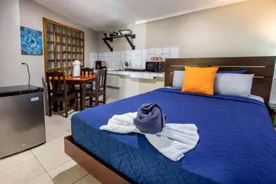 a bedroom with a blue bed with towels on it at Hotel Casa del Arbol Manuel Antonio in Quepos