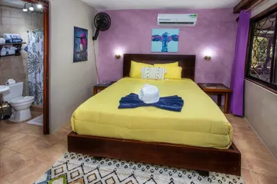 a bedroom with a bed with a hat on it at Hotel Casa del Arbol Manuel Antonio in Quepos