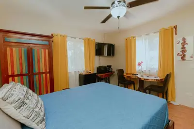 a bedroom with a blue bed and a dining table at Hotel Casa del Arbol Manuel Antonio in Quepos