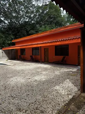 an orange building with two benches in front of it at Cabinas Vif Guanacaste