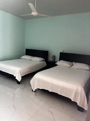 two beds sitting next to each other in a room at Cabinas Vif Guanacaste