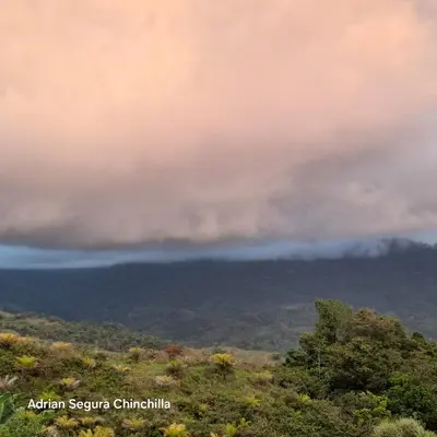 a fire in the sky over a hill with trees at Casa de montaña in Quepos