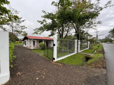 a gate on the side of a road next to a house at Charming 3-Bedroom House Rental in Paquera, Costa Rica in Paquera