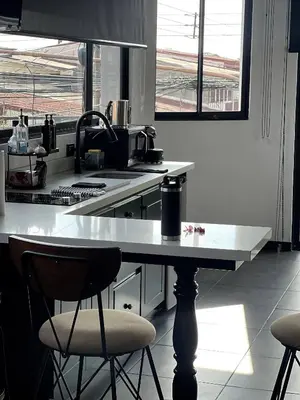 a kitchen with a table and two chairs at 5 min from AirPort SJO OASIS LOFT in Alajuela City