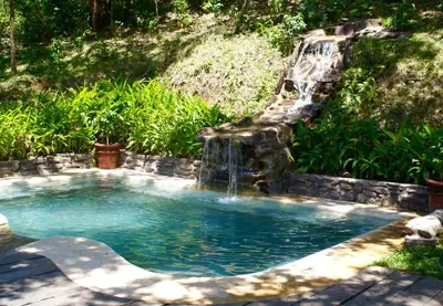 a plunge pool with a waterfall in a backyard at Vida Aventura Ranch in Tanques