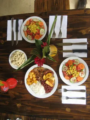 a wooden table with plates of food on it at Vida Aventura Ranch in Tanques