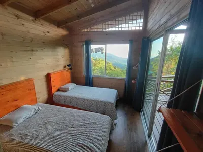 a bedroom with two beds in a wooden cabin at El Verde Pacifico in San Luis