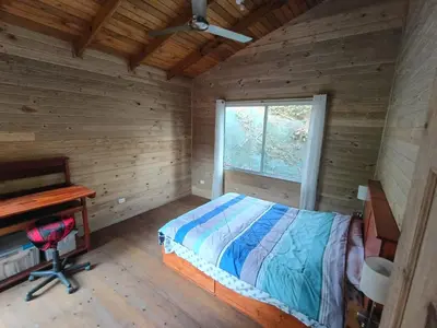 a bedroom with a bed and a desk and a window at El Verde Pacifico in San Luis
