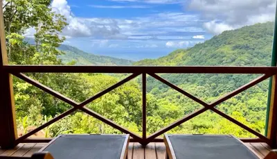 a balcony with two chairs and a view of the mountains at El Verde Pacifico in San Luis