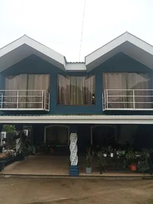 a blue house with a vase in front of it at Ordoñez in Bijagua