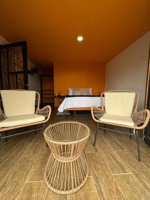 a room with two chairs and a bed in the background at Four Elements House Peace & Nature in Monteverde in Monteverde Costa Rica