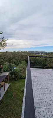 a walkway with a bench and a view of a field at Four Elements House Peace & Nature in Monteverde in Monteverde Costa Rica