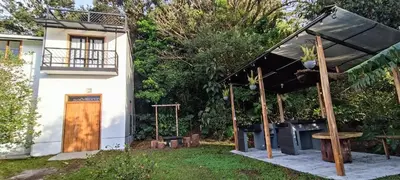 a small house with a black awning and a wooden door at Four Elements House Peace & Nature in Monteverde in Monteverde Costa Rica