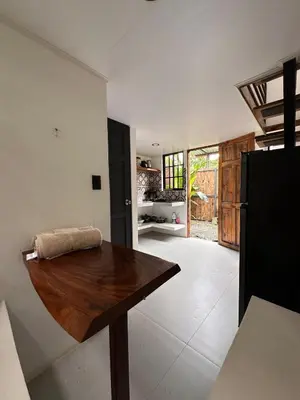 a kitchen with a wooden table in a room at Mini House 2 in Uvita