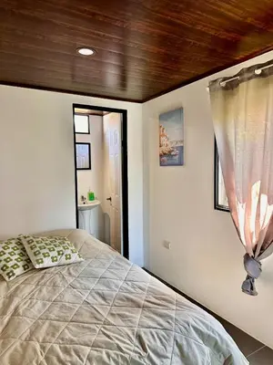 a bedroom with a bed and a wooden ceiling at Mini House 2 in Uvita