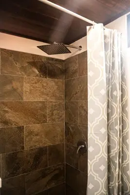 a bathroom with a shower with a shower curtain at Mini House 2 in Uvita