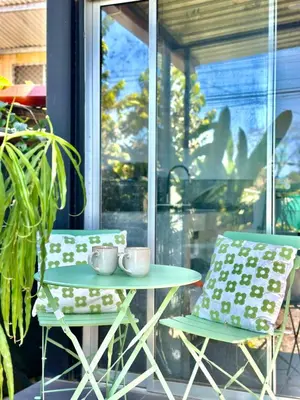 a table and two chairs on a patio with a window at Mini House 2 in Uvita