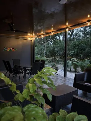 a patio with chairs and a table and a plant at Casitas Maya in Nicoya