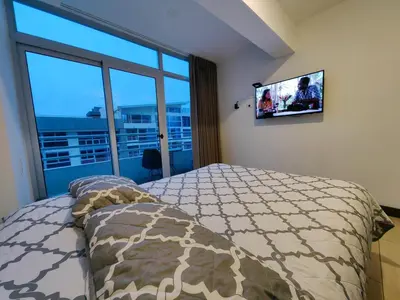 a bedroom with a bed and a flat screen tv at 1702 Torres los Yoses cozy apartment on the 17th floor with balcony in San José