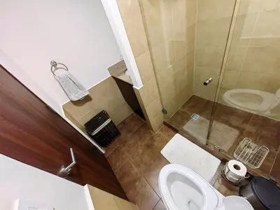 a small bathroom with a toilet and a shower at 1702 Torres los Yoses cozy apartment on the 17th floor with balcony in San José
