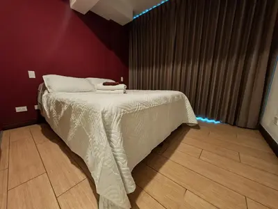 a bedroom with a bed with a white comforter at 1702 Torres los Yoses cozy apartment on the 17th floor with balcony in San José