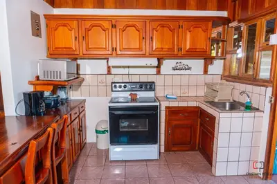 a kitchen with wooden cabinets and a stove top oven at Casa Los Chorros in Agua Azul