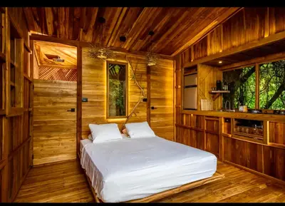 a bedroom with a bed in a wooden room at Pura selva tree house in Tamarindo