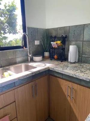 a kitchen counter with a sink and a window at Hawk Hope Tiny House with Sunset Views in Bagaces