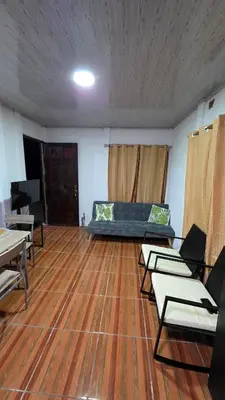 a living room with a couch and a wooden floor at Casa Brisa Azul 5 minutes from the beach in La Cruz