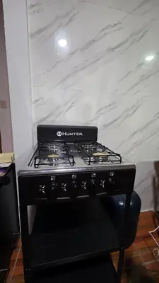 a stove top oven in a kitchen with a marble wall at Casa Brisa Azul 5 minutes from the beach in La Cruz