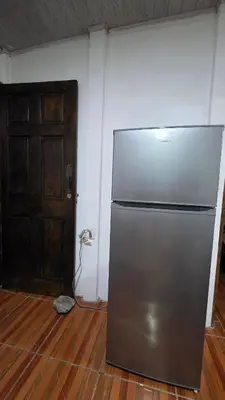 a stainless steel refrigerator in a room with a door at Casa Brisa Azul 5 minutes from the beach in La Cruz
